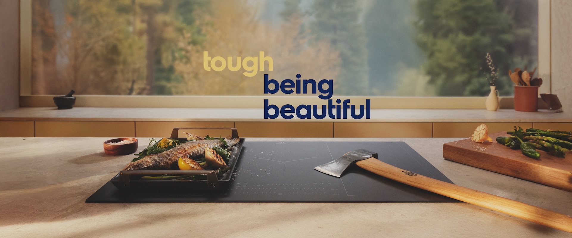 An axe is placed on an induction hob with SaphirMatt surface next to grilled food.